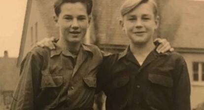 two young men, standing arm in arm