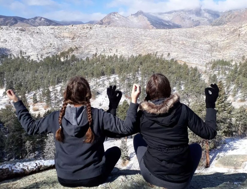 The author and her friend praying in the Rocky Mountains.