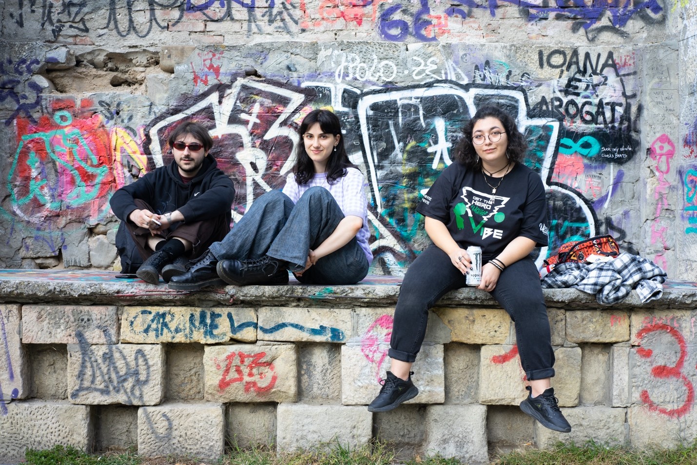 Three Romanian students sitting on a wall.