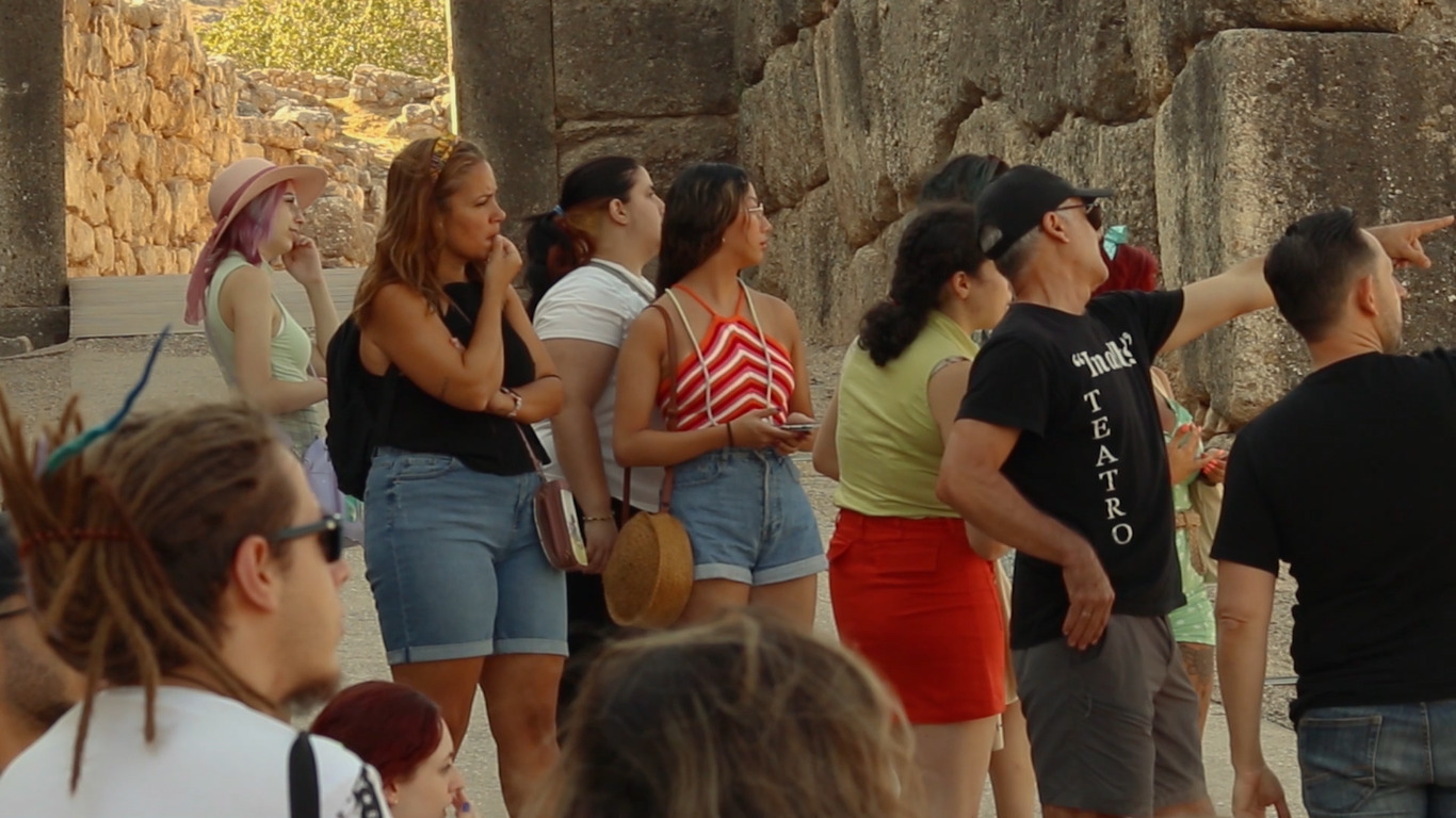 The Lions Gate, one of Ancient Greece's best preserved monuments. In Albis Teatro's director Pepe points at something in the horizon while his students listen to him with great interest.
