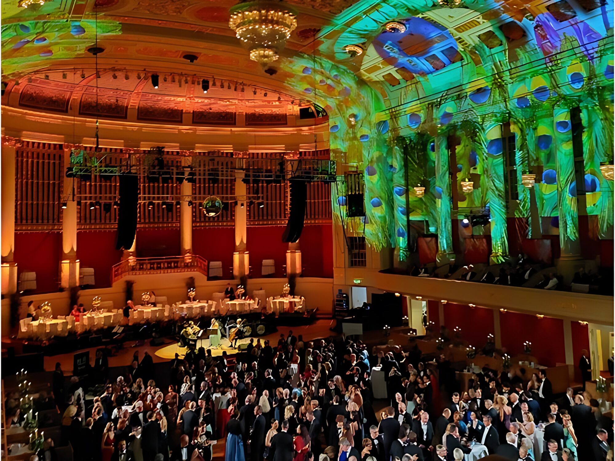 A hall full of people dancing beneath a green, shimmering ceiling