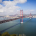 The 25 de Abril Bridge in Lisbon, a red metallic hanging bridge that crosses over the Tagus River