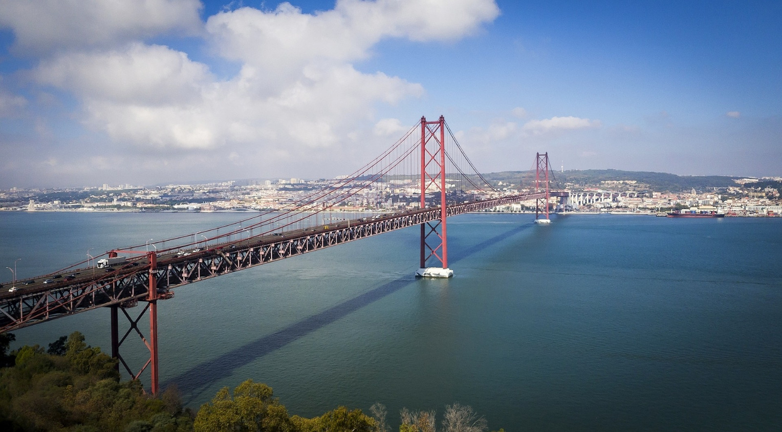 The 25 de Abril Bridge in Lisbon, a red metallic hanging bridge that crosses over the Tagus River